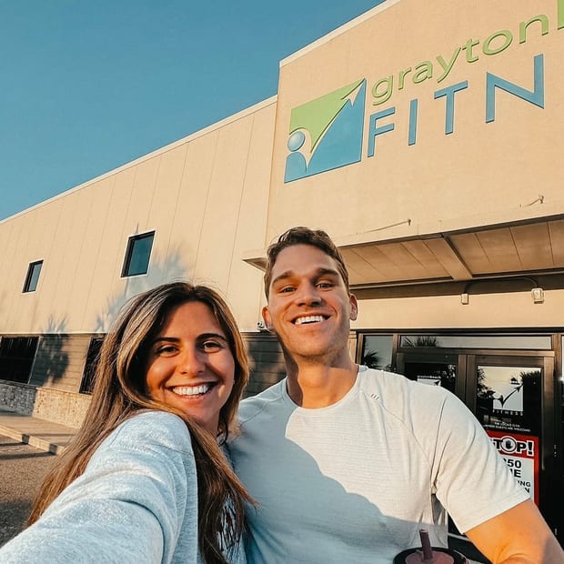 Two visitors smiling outside Grayton Beach Fitness on 30A