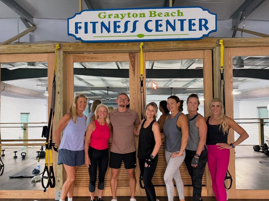 Members in the TRX bay under the Grayton Beach Fitness Center sign at 55 Logan Ln